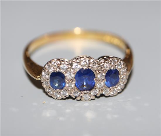 A modern 18ct gold, sapphire and diamond set triple cluster ring, size Z.